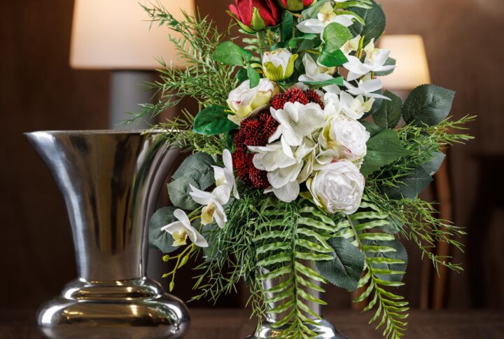 Vista frontale del mazzo di fiori per defunti - Un tributo floreale permanente ed elegante con rose rosse e margherite bianche per commemorare i cari.