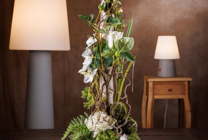 Composizione di fiori artificiali finti con rose e tronchi di betulla naturali