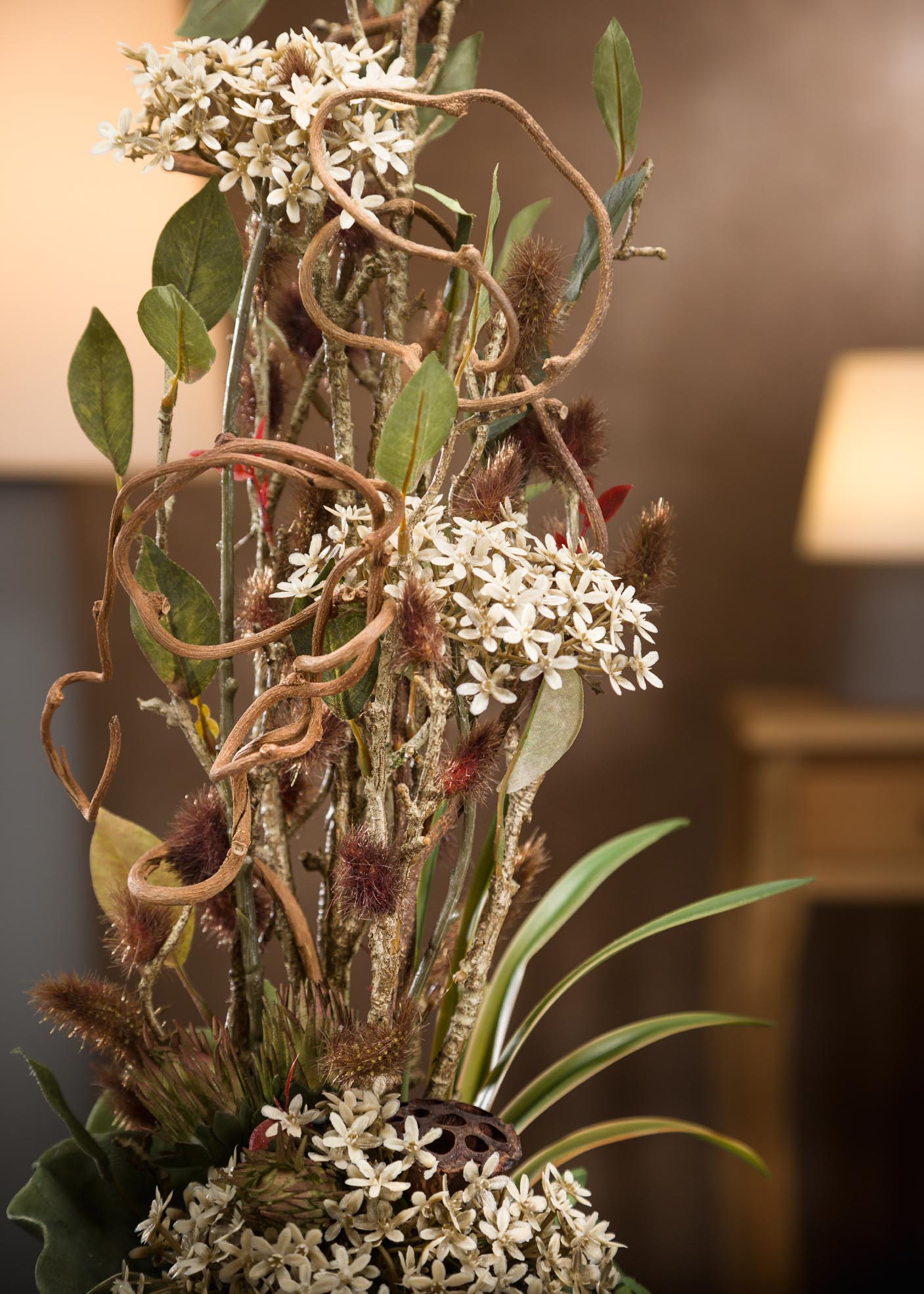 Composizione di fiori artificiali realistici ricoperto di foglie naturali marroni