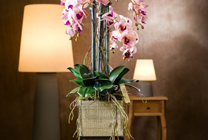Composizioni con orchidee in vaso di legno e metallo - Vista frontale della composizione con orchidee fucsia screziate che sembrano vere