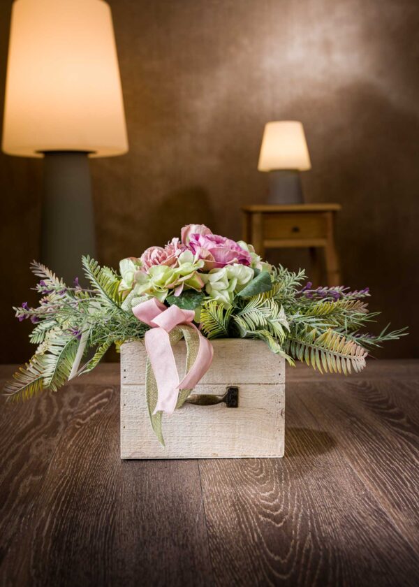 Vista generale della piccola composizione floreale artificiale con rose e vaso in legno