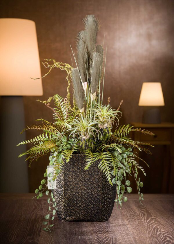 Vista frontale della pampas composizione, un elegante capolavoro floreale con fiori artificiali di alta qualità, foglie di felce e piante grasse, disposti in un vaso decorativo dal design moderno.