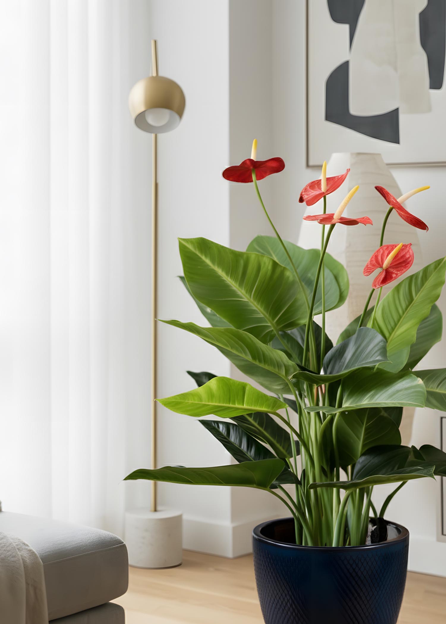 Vista ambientata in salotto con stile nordico – pianta artificiale accanto a divano bianco e arredi minimal