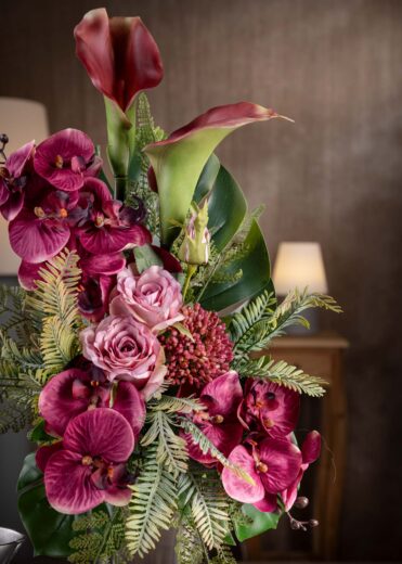 Dettaglio ravvicinato delle orchidee finte per cimitero in sfumature di rosa intenso e fucsia, con dettagli realistici e tonalità vivide