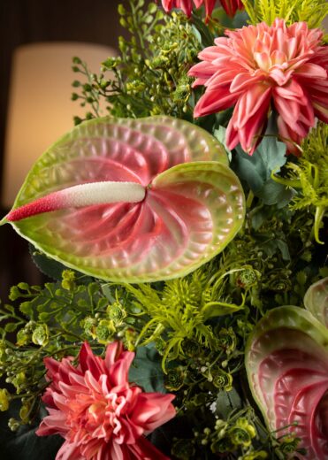 Dettaglio particolareggiato di foglie e fiori di una composizione floreale invernale per cimitero – eleganza e simbolismo in ogni elemento