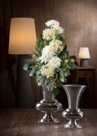 Vista frontale di un mazzo di fiori finti per cimitero in tonalità di bianco, composto da dalie e allium bianchi, con ricco fogliame verde per un effetto delicato e duraturo