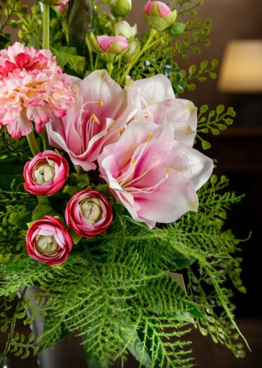 Dettaglio ravvicinato di fiori artificiali rosa e verdi in un bouquet, con focus su petali realistici e freschi – bouquet fiori finti per cimitero