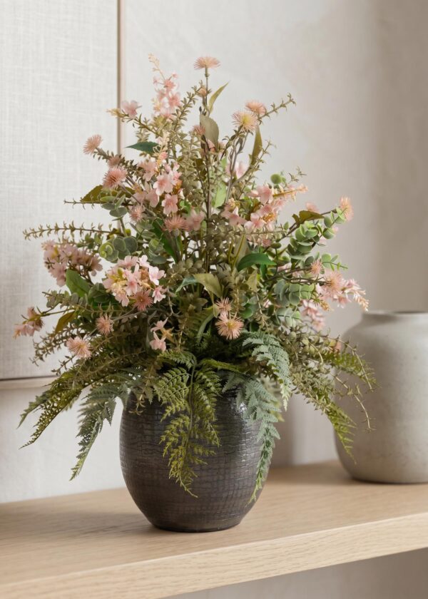 Fiori artificiali in vaso di ceramica su madia in ambiente moderno