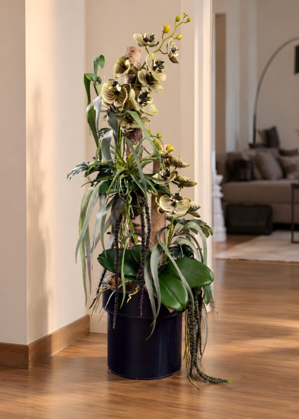 Composizione floreale con tronchi naturali di Betulla, Orchidee screziate e fogliame ricadente nel vaso nero, vista completa.